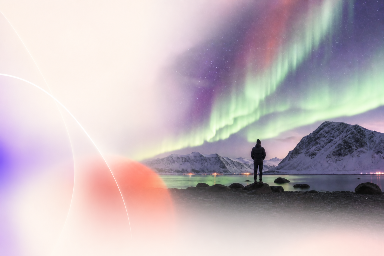 A traveler standing beneath vivid northern lights beside an arctic lake