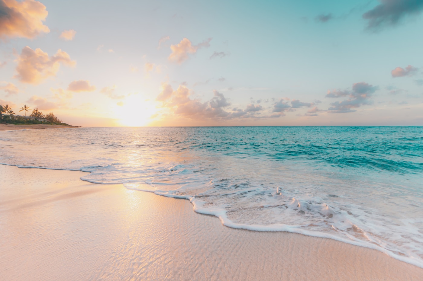 A calm beach and turquoise sea in early morning light
